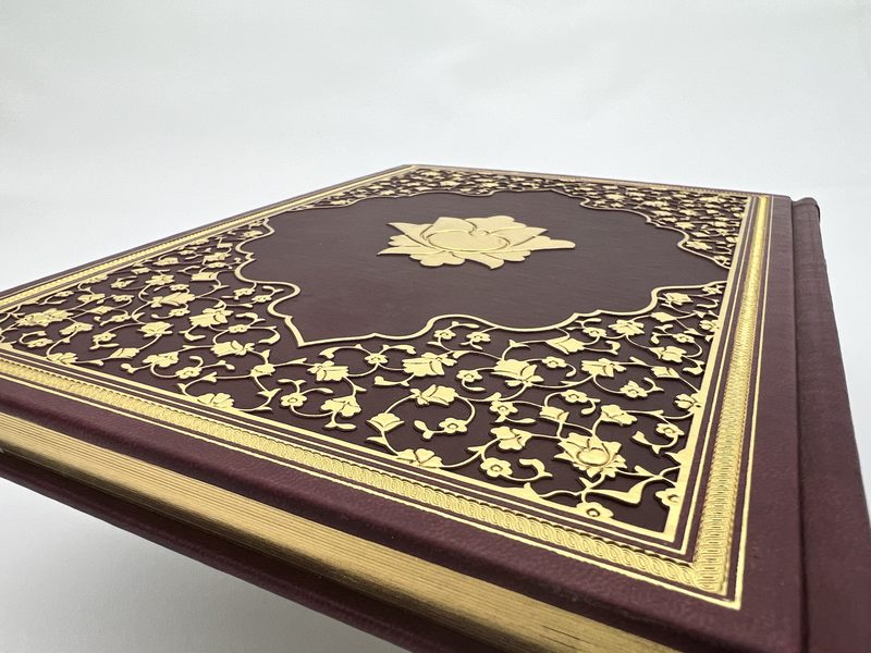 Maroon leather corner with gold tooling and gilt edges